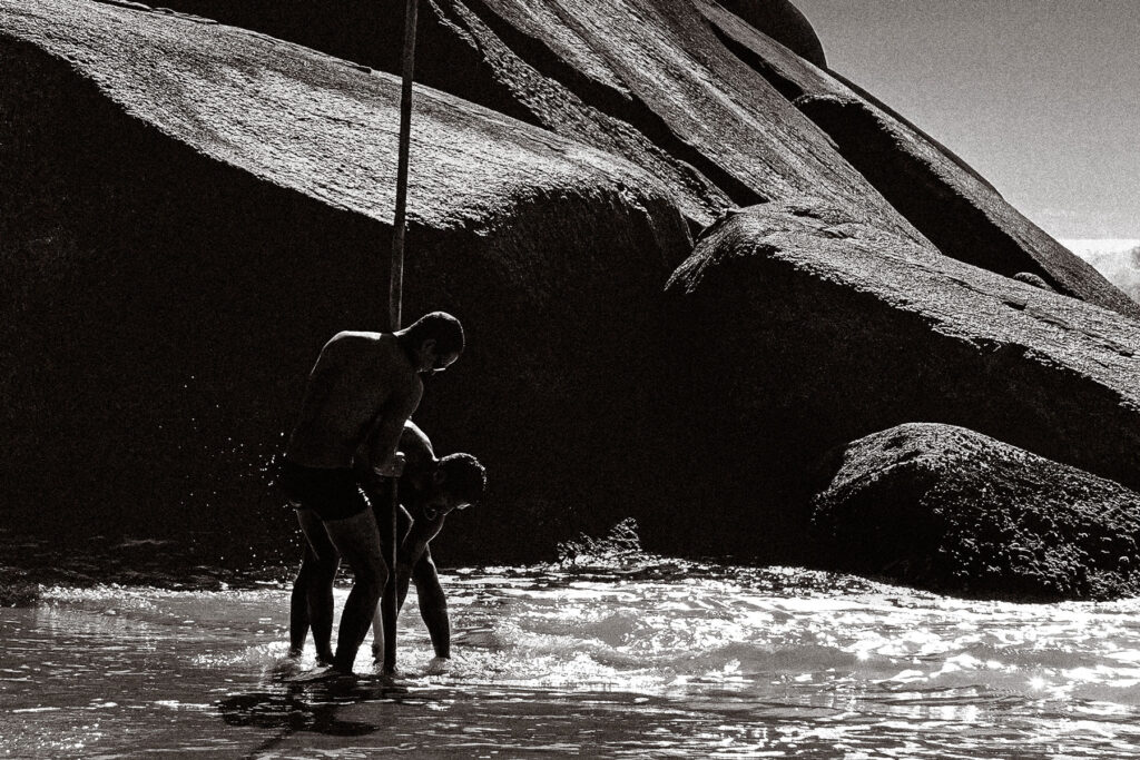 Two lifeguards raise a flag in the sand